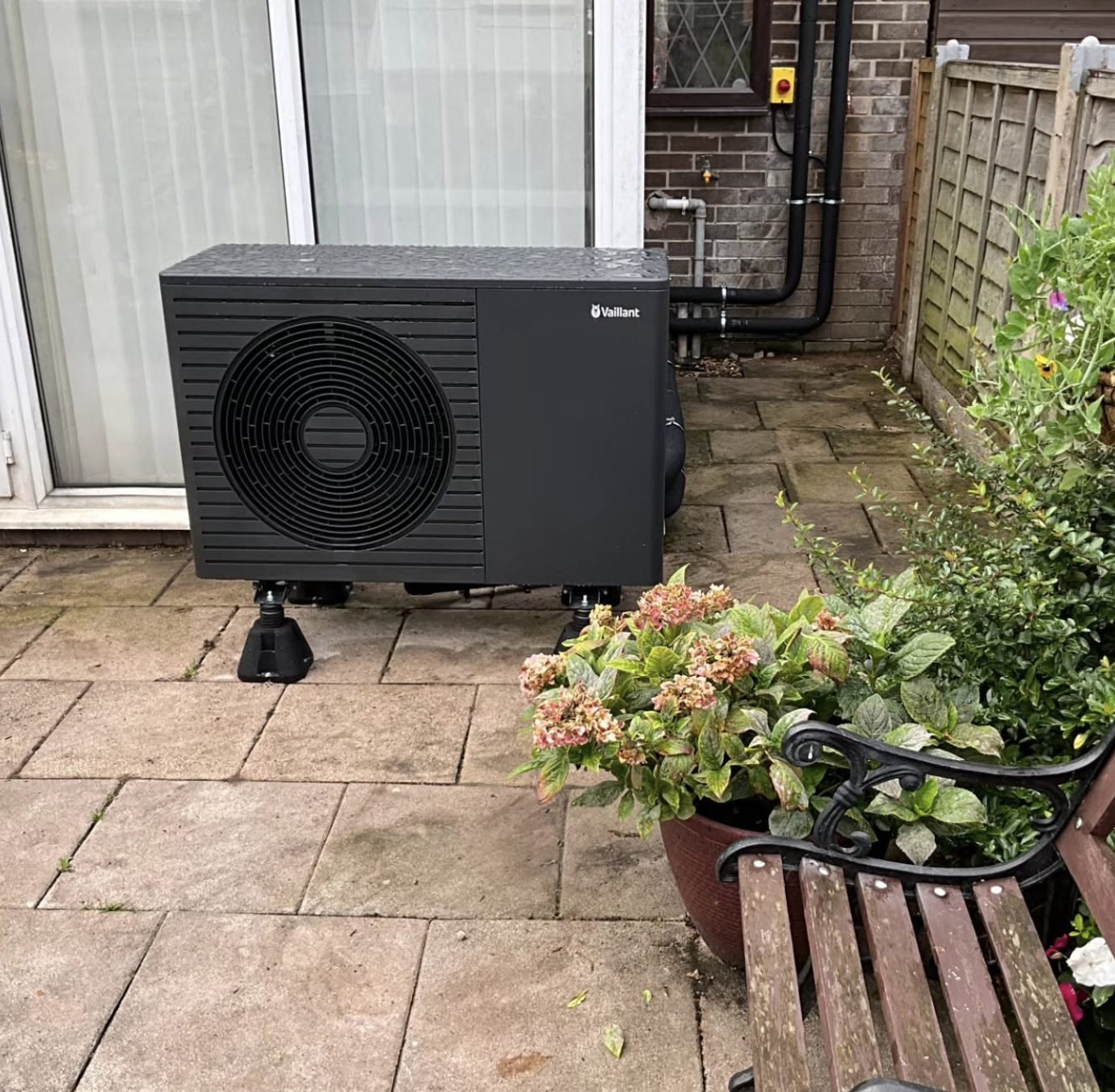 Vaillant air source heat pump installed on a patio beside a conservatory